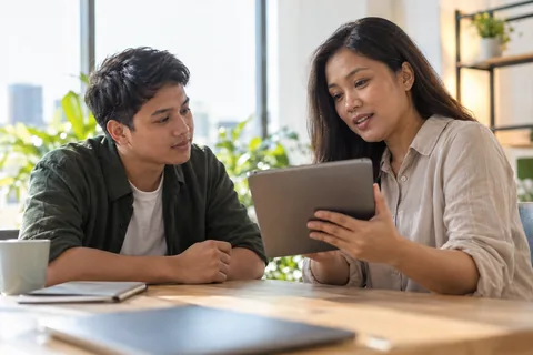 Illustrative photo of an operations manager reviewing a tablet with a colleague.